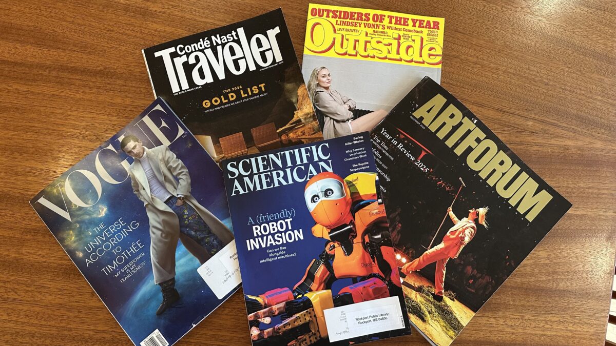 five magazines—conde nast traveler, outside, vogue, scientific american, and artforum—are spread out on a wooden surface, each featuring colorful covers with photos and bold headlines.