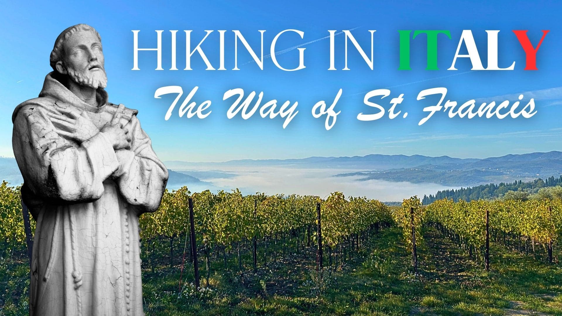 a statue of st. francis stands beside text reading hiking in italy: the way of st. francis over a scenic landscape of green vineyards and distant hills under a clear blue sky.