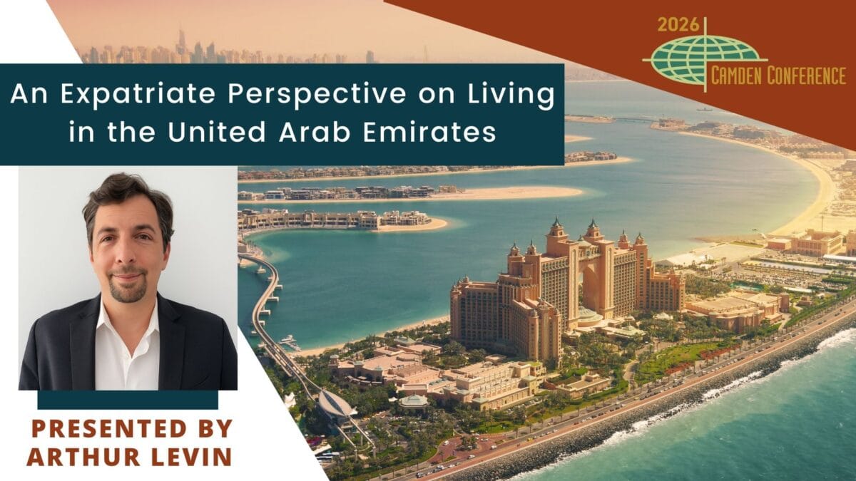 a conference slide shows the atlantis hotel on dubai’s palm jumeirah, with text: “an expatriate perspective on living in the united arab emirates.” inset: a man in a suit and text “presented by arthur levin.”.